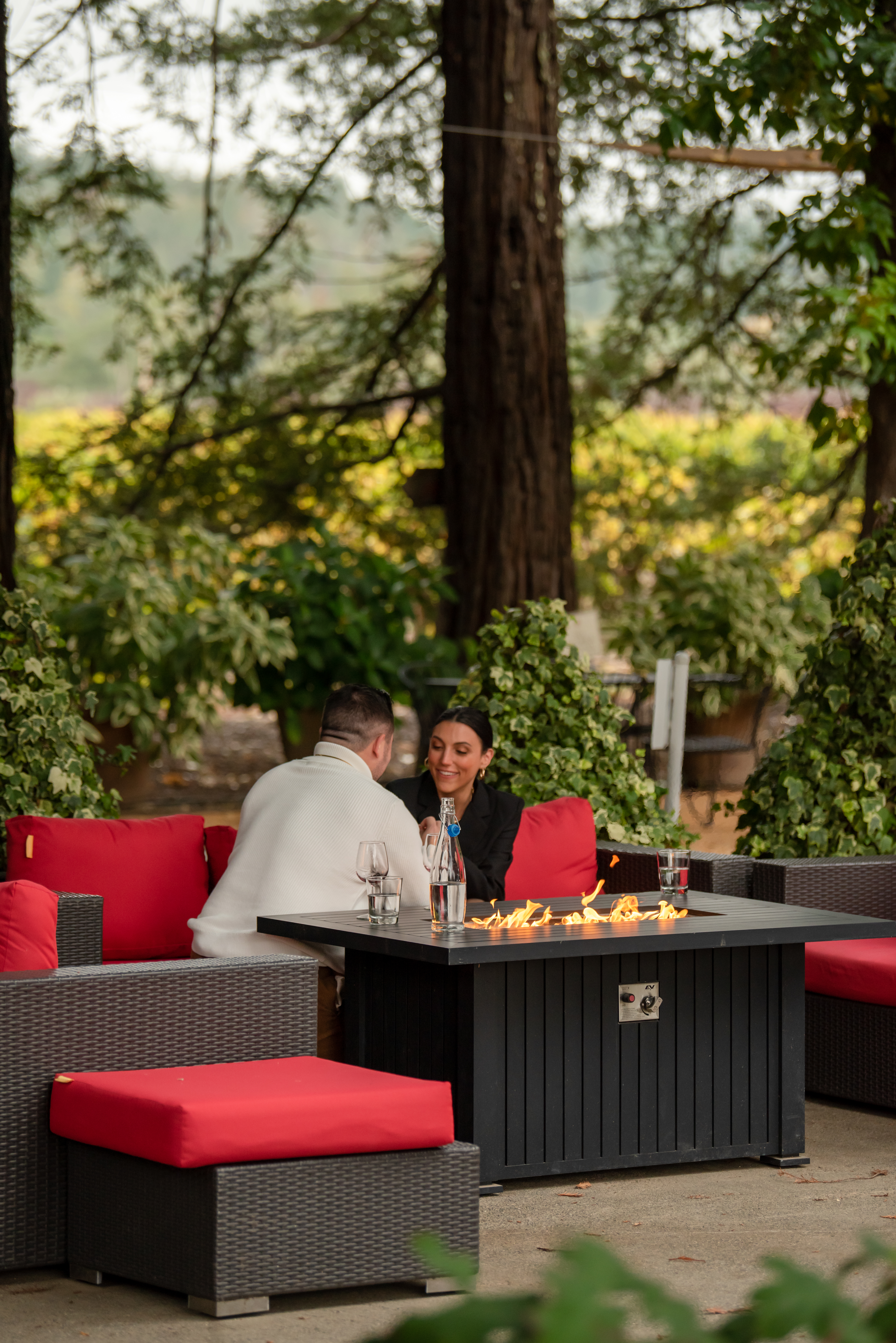 Beautiful Places to Propose in Sonoma California - Trentadue Winery. With fire pit on, a man in a cream sweater asks a woman in a black blazer to be his wife.