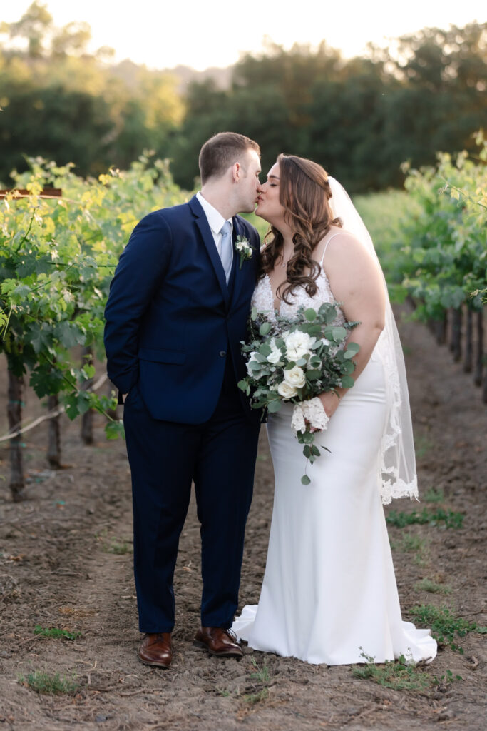Sunset kiss between bride and groom at deLorimier Winery Wedding Venue in Sonoma County.