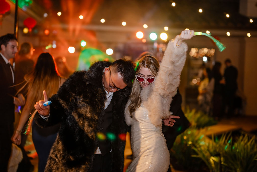 Wedding after party, bride and groom in fur coat with lights.