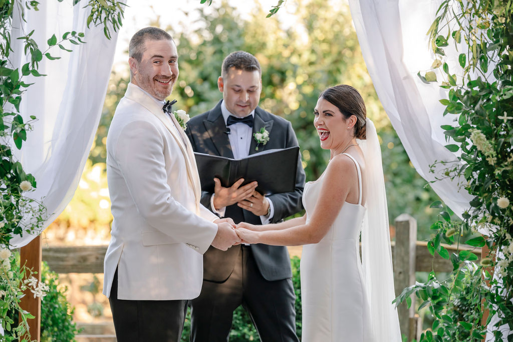 How to have a wedding at Vine Hill House in Sonoma. Couple holding hands under awning. 