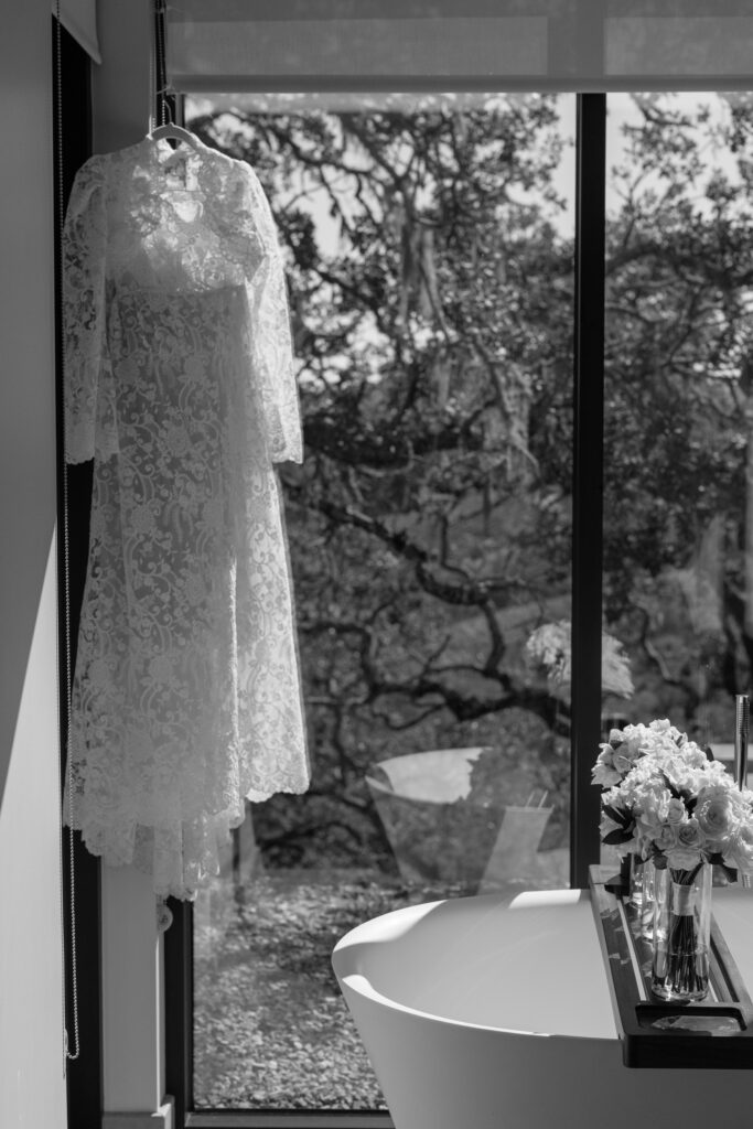Wedding detail photos in bathroom with flowers and dress.
