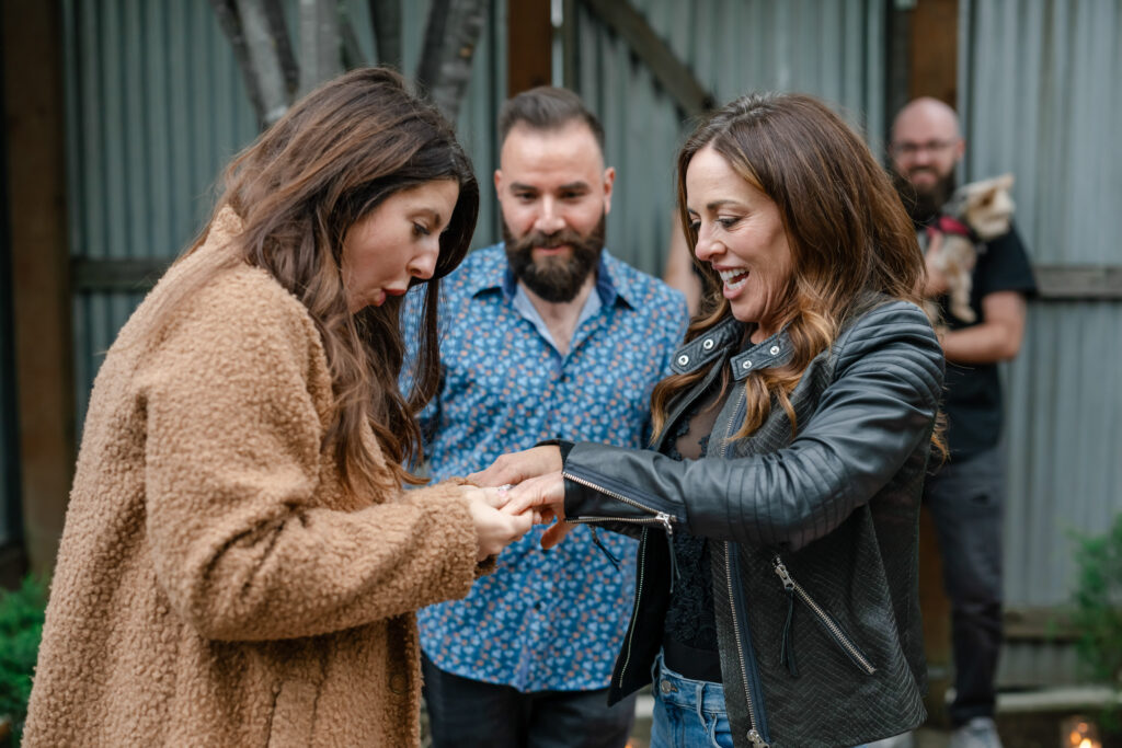 Emotional proposal moment at Carneros Resort and Spa as one partner places a ring on the other’s finger, surrounded by close friends during a Napa Valley proposal.