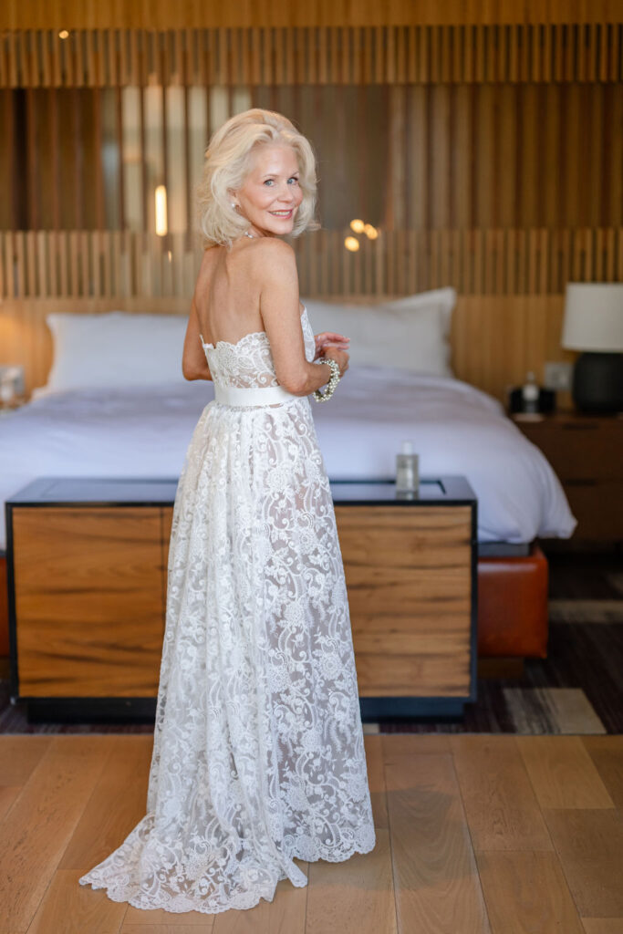 Bride standing in her wedding suite at Montage Healdsburg, wearing a lace gown with open back before the ceremony