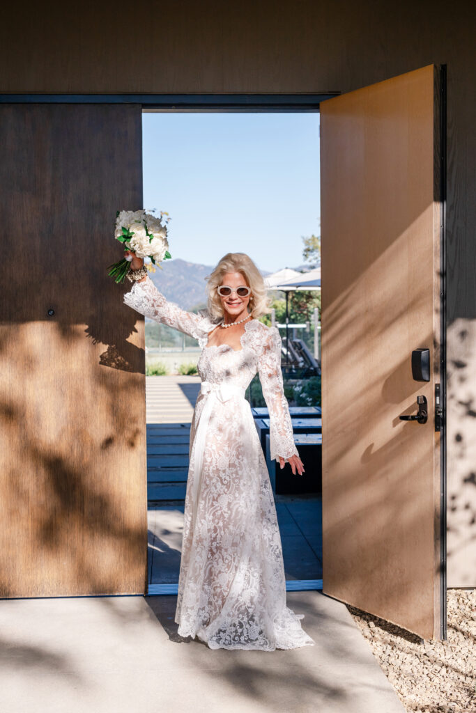 Bride standing in her wedding suite at Montage Healdsburg, wearing a lace gown with open back before the ceremony