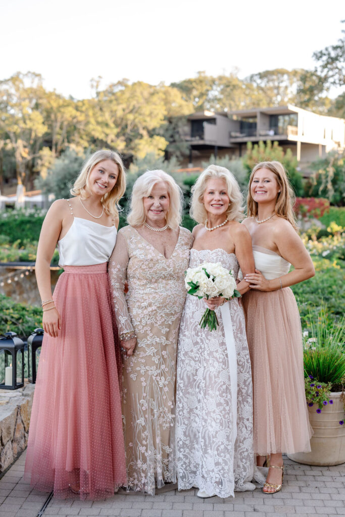Bride standing with family during a family portrait at Montage Healdsburg, surrounded by gardens and vineyard views at golden hour.