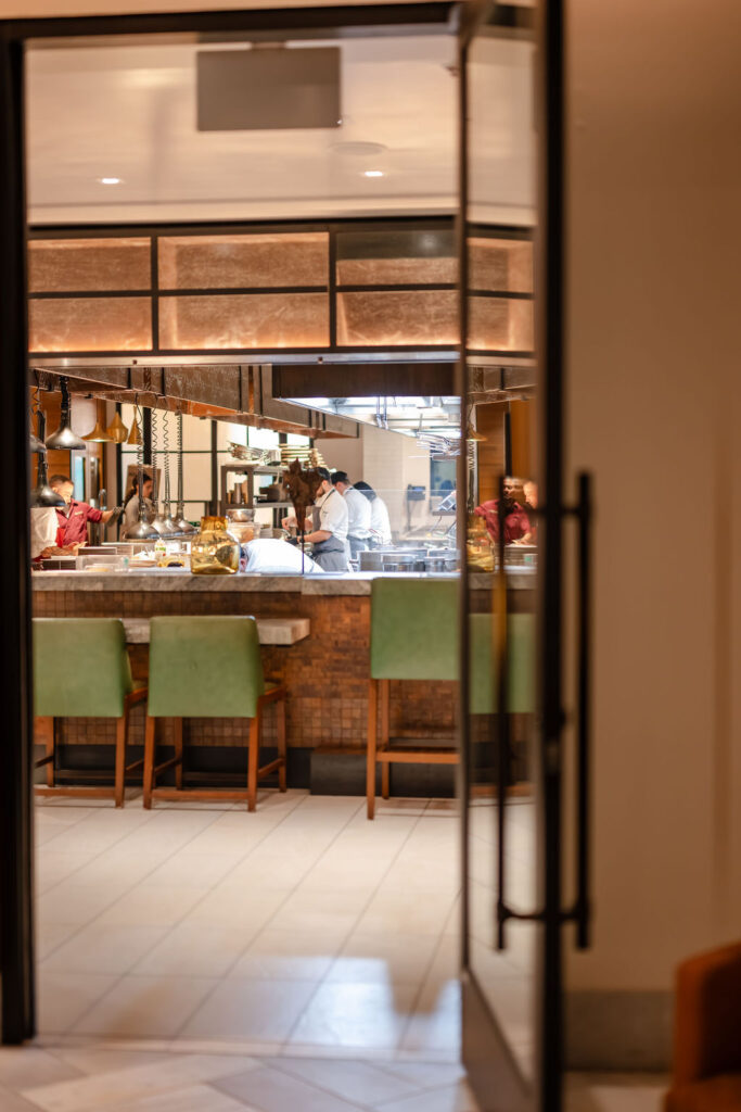 Open kitchen and chef’s counter at Montage Healdsburg during wedding reception, with warm lighting and guests dining nearby.