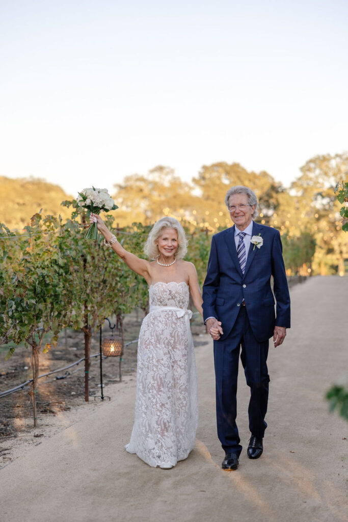 Bride and groom walking hand in hand through the vineyards at Montage Healdsburg