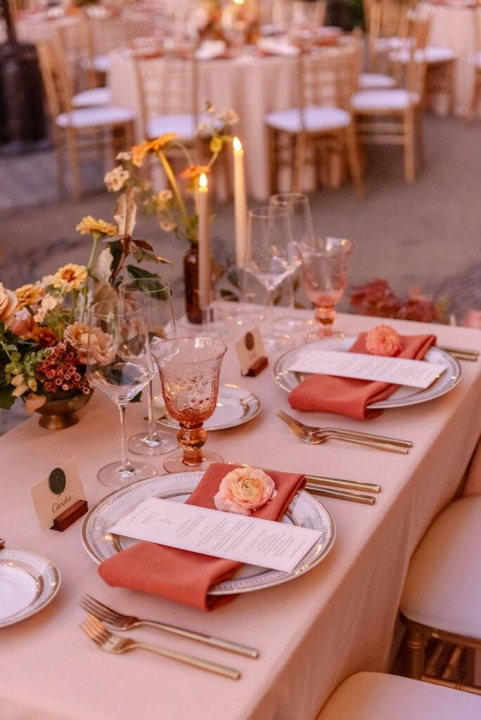 Elegant wedding place setting with peach linen, gold flatware, and floral details at a Buena Vista Winery reception in Sonoma wine country.