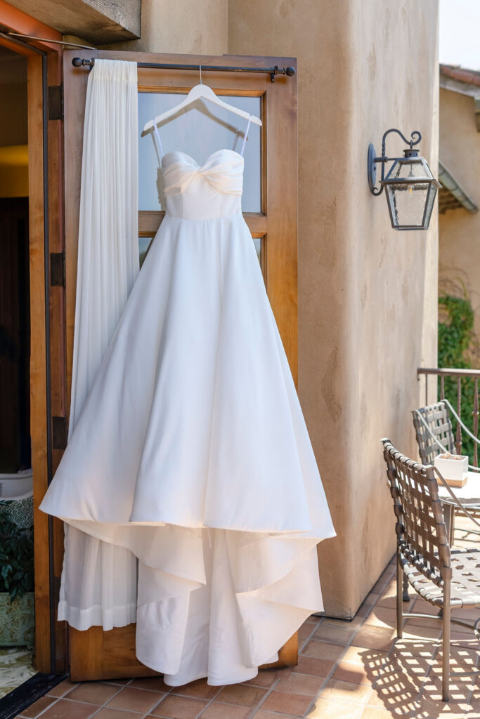 Wedding dress hanging outside villa at Mayacama Golf Club in Sonoma during wedding day preparations.