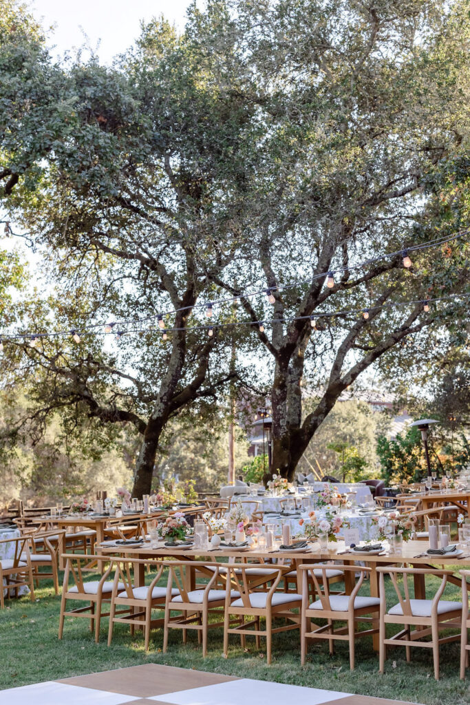 Outdoor wedding reception tables under oak trees at Healdsburg vineyard, photographed by Alicia Parks Photography